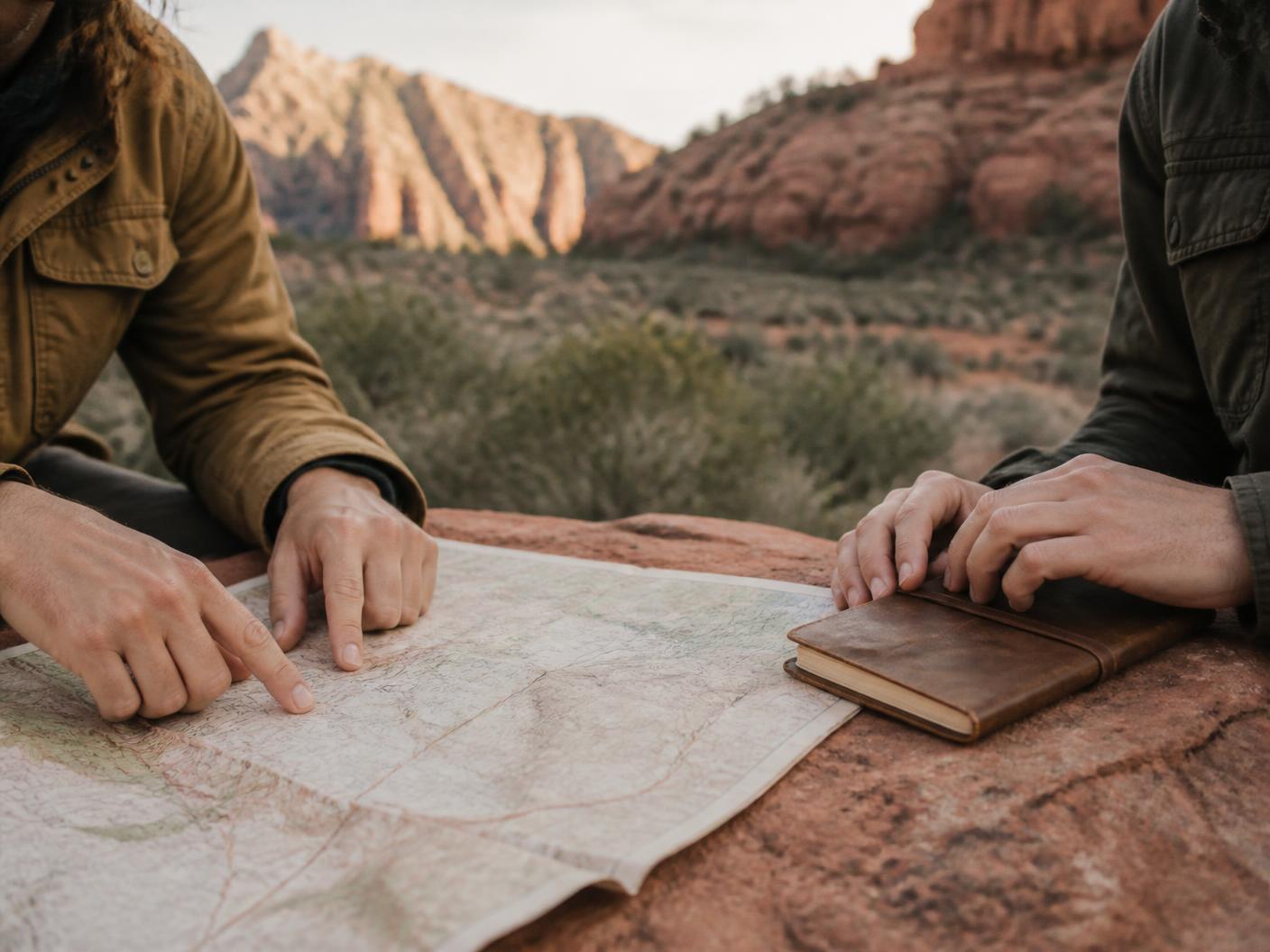 A planner reviewing maps and notes at a red rock trailhead in Sedona